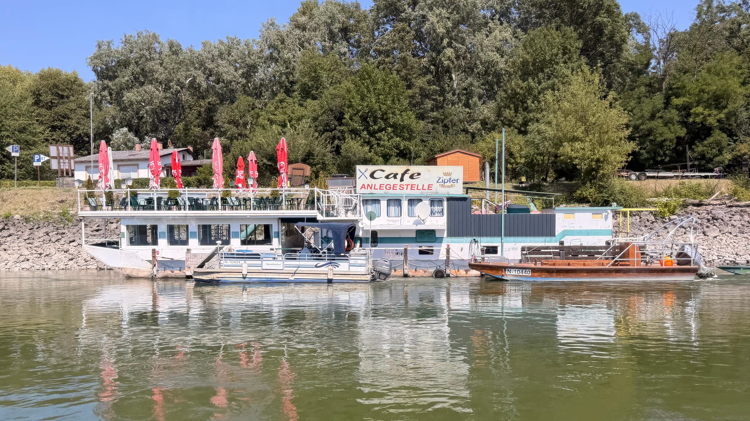 Cafés y embarcaderos flotantes amarrados en la orilla del Danubio